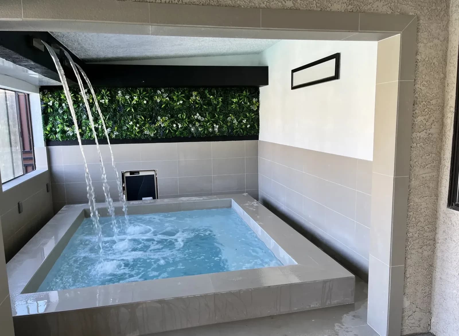 Covered spa with waterfall jets and a living green wall at the Spacious Luxury estate